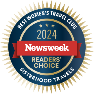 Circular badge with gold sunburst edges featuring text: "Best Women's Travel Club," "2024 Newsweek Readers' Choice," and "Sisterhood Travels" on a blue and red background.