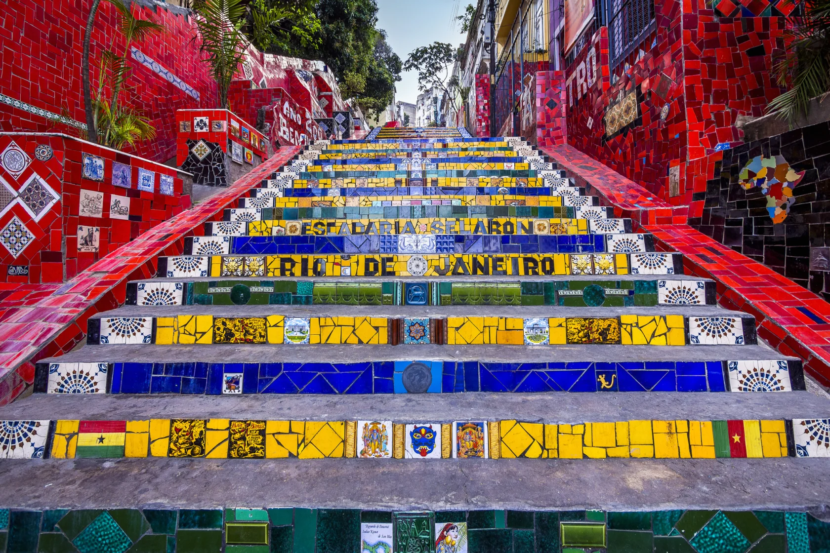Colorful tiled steps of Escadaria Selarón in Rio de Janeiro, featuring vibrant red, yellow, and blue designs with artistic patterns.