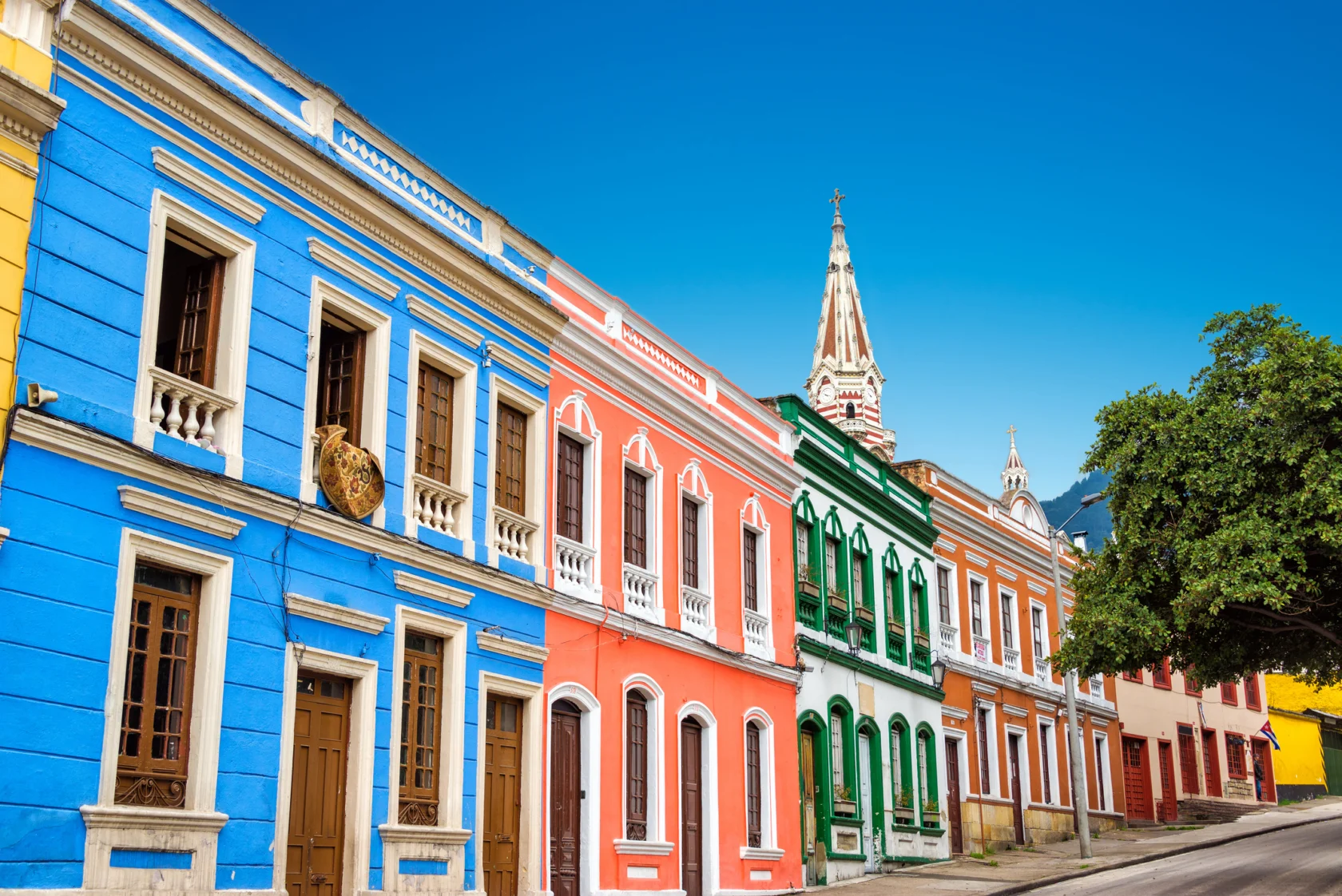 Colorful colonial-style buildings line a street with a clear blue sky above.