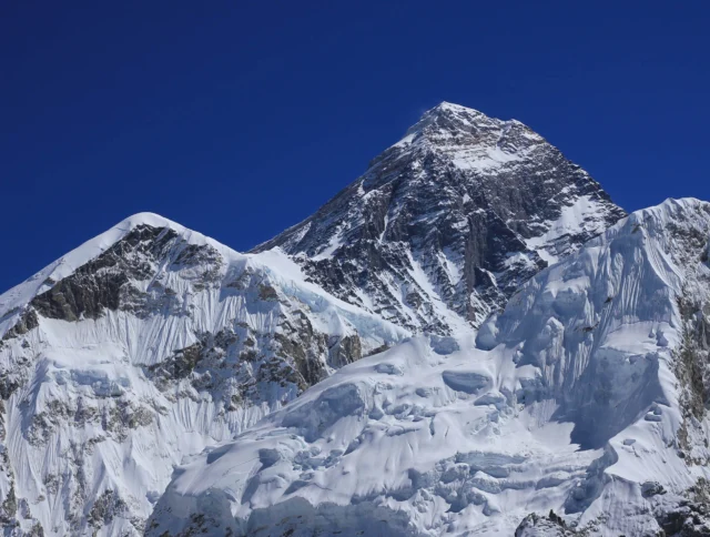 Snow-covered Mount Everest against a clear blue sky.