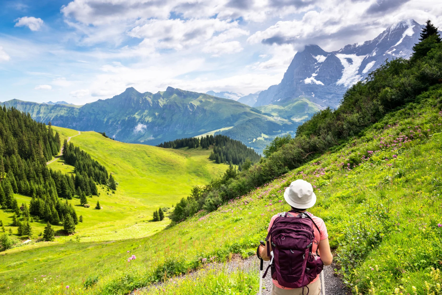Switzerland Travel - woman hiking through the Mountain view trail in the Swiss Alps in the Jungfrau region.