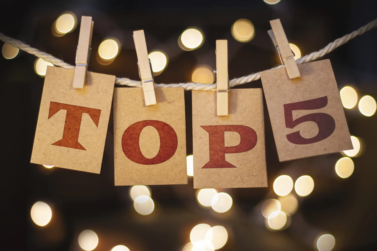 Cards with "TOP 5" are clipped to a rope against a backdrop of blurred lights.